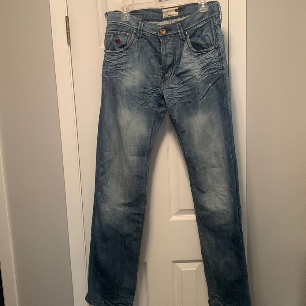Mens nice jeans with a little tear by belt loop
